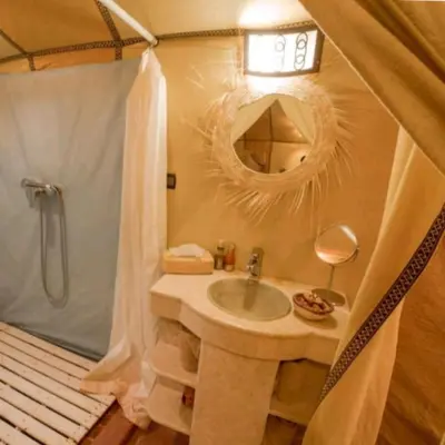 a bathroom with a sink and a shower and a mirror at Original Luxury Camp in Merzouga