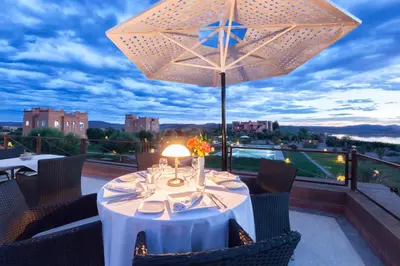 a table with a white table cloth and a large umbrella at Sultana Royal Golf in Afeggou