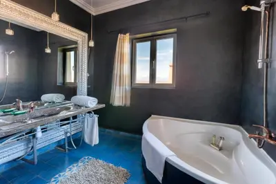 a bathroom with a tub and a sink and a mirror at Sultana Royal Golf in Afeggou