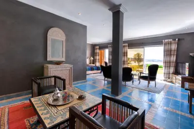 a living room with a table and chairs at Sultana Royal Golf in Afeggou