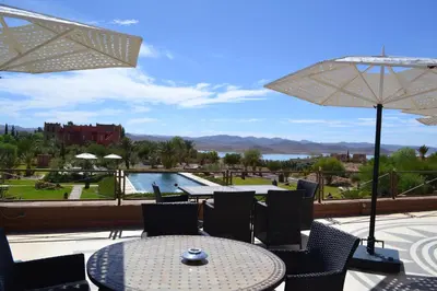 a patio with a table and chairs and a pool at Sultana Royal Golf in Afeggou