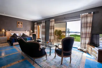a living room with a bed and chairs and a television at Sultana Royal Golf in Afeggou