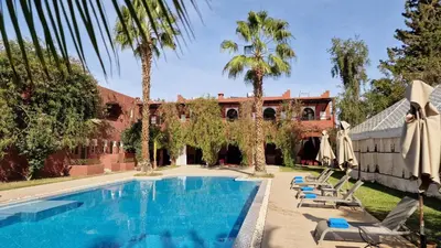 a swimming pool with chairs and a building at Palace Africa - Marrakech Palmeraie in Marrakech