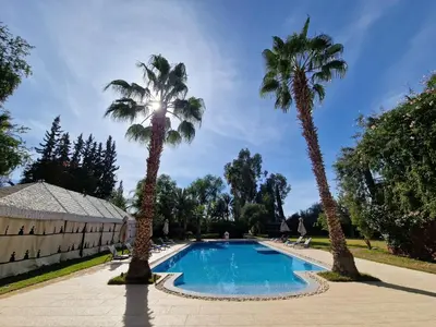 a pool with two palm trees in a yard at Palace Africa - Marrakech Palmeraie in Marrakech