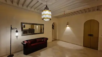 a living room with a couch and a mirror at Palace Africa - Marrakech Palmeraie in Marrakech