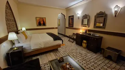 a hotel room with a bed and a desk and a room at Palace Africa - Marrakech Palmeraie in Marrakech