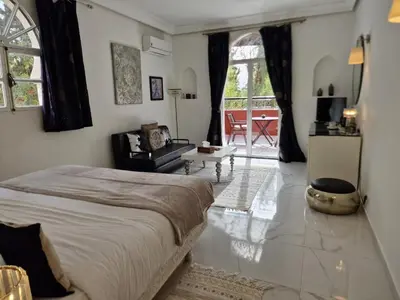 a bedroom with a bed and a living room at Palace Africa - Marrakech Palmeraie in Marrakech