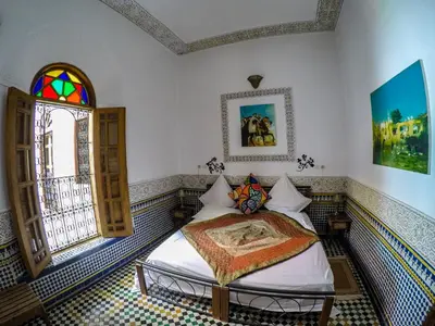 a bedroom with a bed and a window at Riad La Clé De Fès in Fès