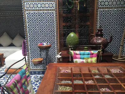 a room with a table and a wall with tiles at Riad La Clé De Fès in Fès