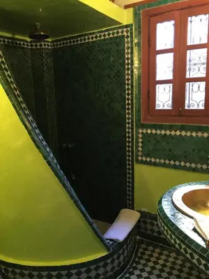 a bathroom with a tub with a sink and a window at Riad La Clé De Fès in Fès