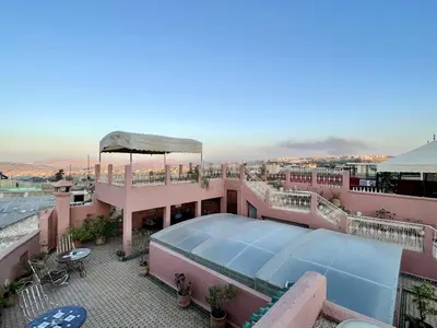a building with a pool on top of a roof at Riad La Clé De Fès in Fès
