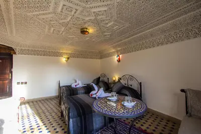 a room with a couch and a table and a ceiling at Riad Hala in Fès