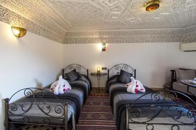 a room with four beds with masks on the ceilings at Riad Hala in Fès