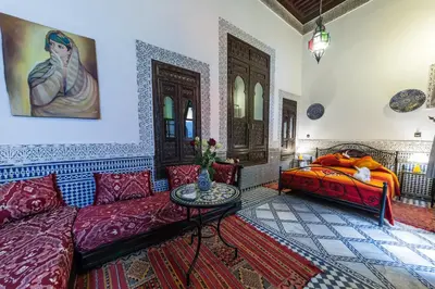 a living room with a couch and a bed at Riad Hala in Fès