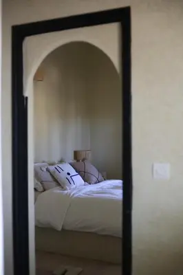 a mirror reflection of a bed in a bedroom at Kasbah des cyprès in Skoura