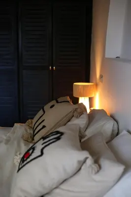 a bed with pillows on it with a lamp at Kasbah des cyprès in Skoura
