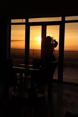 a woman taking a picture of the sunset at Bhalil Farm House in Sefrou