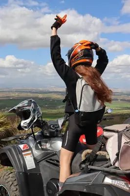 a woman standing on a motorcycle with her arms in the air at Bhalil Farm House in Sefrou