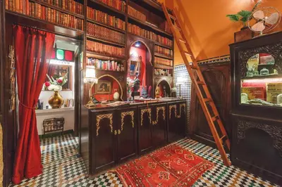 a room with a library with a ladder and books at Riad Le Calife in Fès