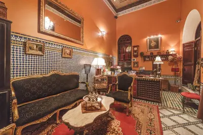 a living room with a couch and chairs and a mirror at Riad Le Calife in Fès