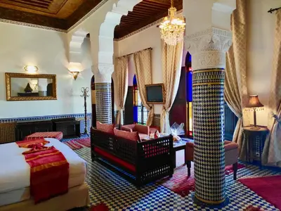 a hotel room with a bed and a couch at Riad Le Calife in Fès