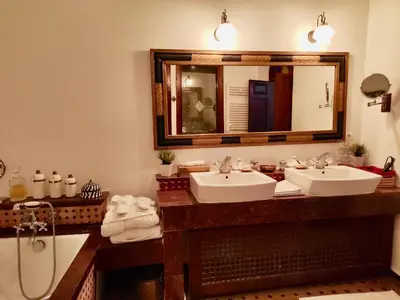 a bathroom with two sinks and a large mirror at Riad Le Calife in Fès