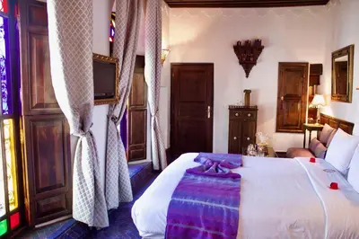 a bedroom with a bed and a tv in it at Riad Le Calife in Fès