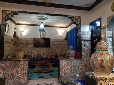 a living room with a large mirror and a room with many things at Mini Riad family Chez Adil Batha Fés in Fès