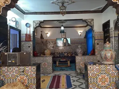 a living room with a large mirror and a table at Mini Riad family Chez Adil Batha Fés in Fès