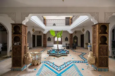 a large room with a palm tree in the middle at Riad Jouba in Merzouga