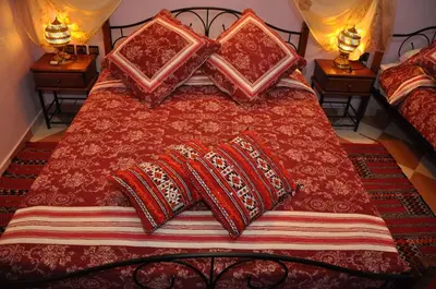 a bed with pillows on top of it with two lamps at Dar Aliane in Fès