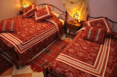 a bedroom with two beds and a table with lamps at Dar Aliane in Fès