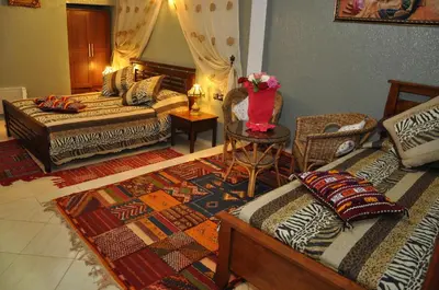 a living room with two beds and a table at Dar Aliane in Fès