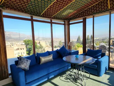 a living room with a blue couch and a table at Le Riad Palais d'hotes Suites & Spa Fes in Fès