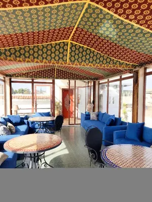a room with blue couches and tables and windows at Le Riad Palais d'hotes Suites & Spa Fes in Fès