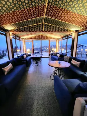 a bar with blue couches and tables and windows at Le Riad Palais d'hotes Suites & Spa Fes in Fès