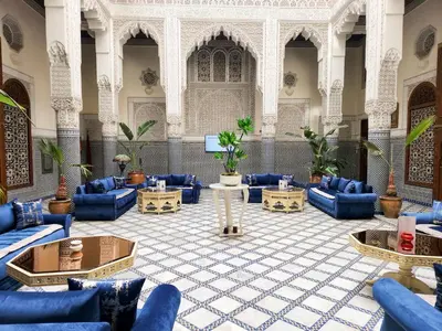 a large lobby with blue couches and tables at Le Riad Palais d'hotes Suites & Spa Fes in Fès