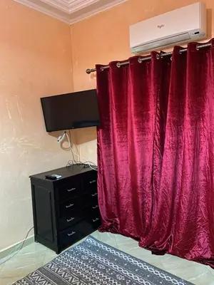 a bedroom with a red curtain and a dresser at Appartement chez Elmehdi in Fès