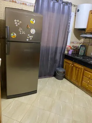 a refrigerator in a kitchen with magnets on it at Appartement chez Elmehdi in Fès