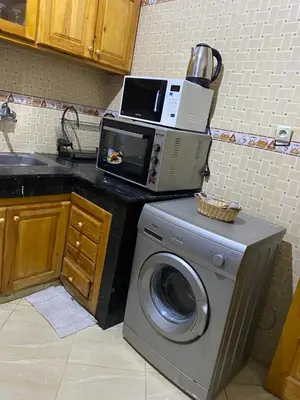 a microwave sitting on top of a washing machine in a kitchen at Appartement chez Elmehdi in Fès