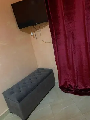 a black ottoman sitting next to a red curtain at Appartement chez Elmehdi in Fès