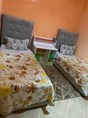 a bedroom with two beds and a nightstand between them at Appartement chez Elmehdi in Fès