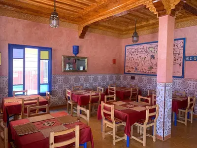 a restaurant with tables and chairs in a room at AMRAOUI Apartment in Rissani