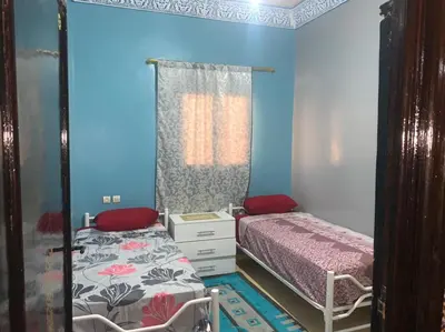 a small bedroom with a bed and a mirror at AMRAOUI Apartment in Rissani
