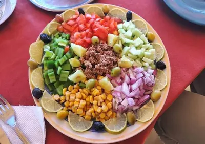 a plate of fruit and vegetables on a table at AMRAOUI Apartment in Rissani