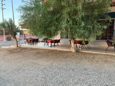 a group of tables and chairs under a tree at AMRAOUI Apartment in Rissani
