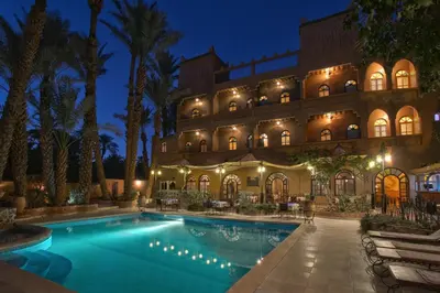 a hotel with a swimming pool at night at Kasbah Sirocco in Zagora