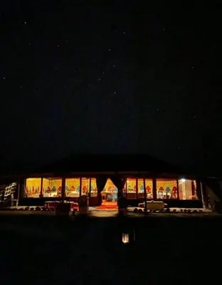 a lit up building at night with lights at Merzouga Sahara Camp in Merzouga