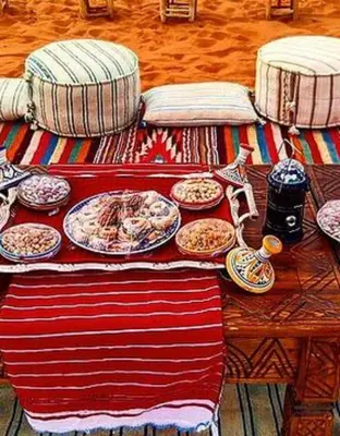 a table with plates of food on top of it at Merzouga Sahara Camp in Merzouga