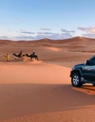 a group of people riding horses in the desert at Merzouga Sahara Camp in Merzouga